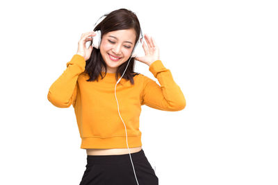 Smiling young woman standing against white background