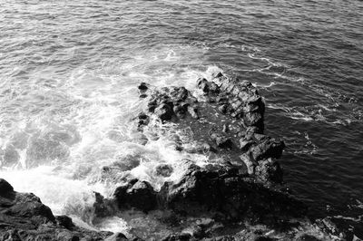 High angle view of waves splashing and crashing  on and over rocks white water surf 