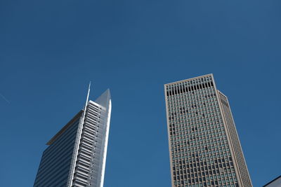 Low angle view of skyscrapers against blue sky