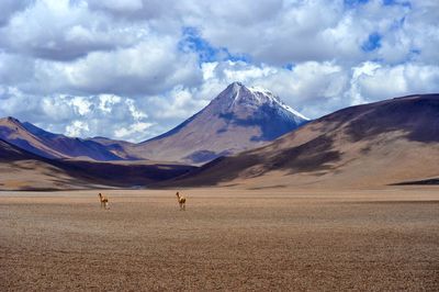 Scenic view of mountains against cloudy sky