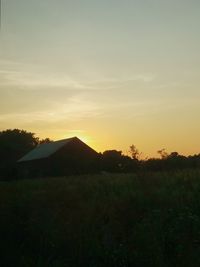 Scenic view of silhouette field against sky during sunset