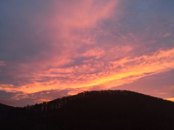 Scenic view of silhouette mountains against dramatic sky