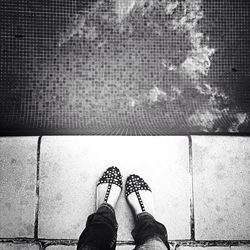 Low section of man standing on tiled floor