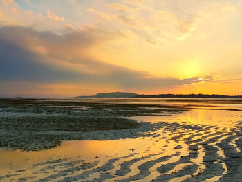 Scenic view of beach against sky during sunset