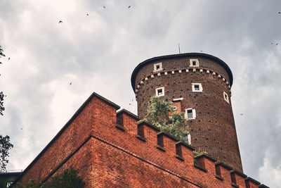 Low angle view of old building against cloudy sky