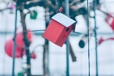 Red wooden birdhouse hanging on the thread.spring park decoration on tree for birds