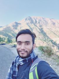 Portrait of young man against mountains