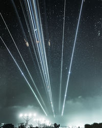 Low angle view of fireworks against sky at night
