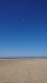 Scenic view of beach against clear blue sky