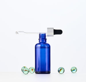 Blue glass bottle with a pipette on a white background. template for cosmetic liquid 