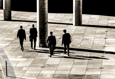 High angle view of businessmen walking on footpath in city