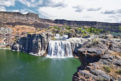 Scenic view of waterfall against sky