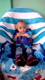 Portrait of cute baby girl lying on bed