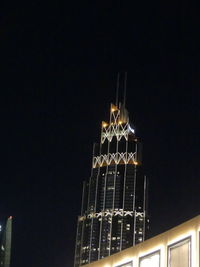 Low angle view of illuminated building against sky at night