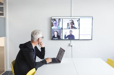 Man in boardroom having video conference