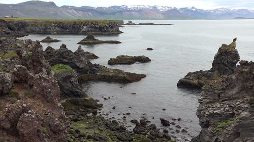 Scenic view of sea and mountains against sky