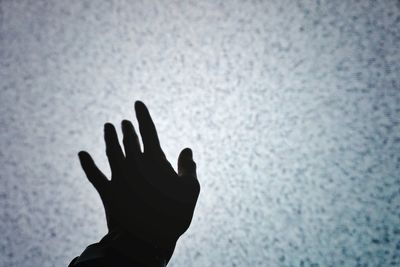 Close-up of silhouette hand against wall