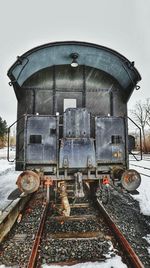 Train on railroad tracks against sky during winter