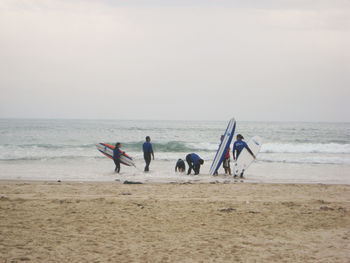 People on beach against sky