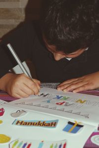 Rear view of a boy holding book