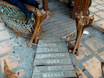 Low section of man lying on table by footpath with text