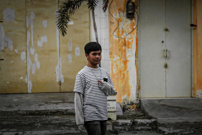 Young man standing against wall