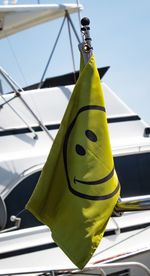 Low angle view of yellow flag against sky