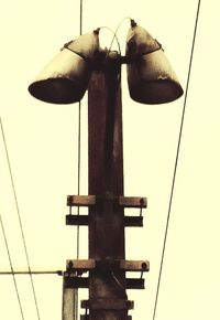 Low angle view of electric lamp against sky