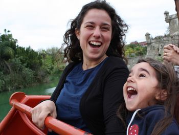 Happy mother and daughter enjoying ride over lake