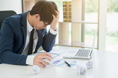 Stressed businessman sitting at desk in office