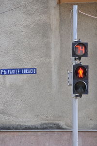 Text on road sign against wall