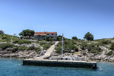 Swimming pool by river against clear blue sky