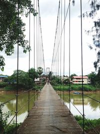 Footbridge amidst plants against sky