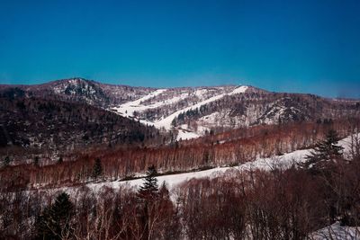 Scenic view of mountains against clear blue sky