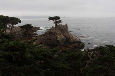 Scenic view of cliff by sea against sky