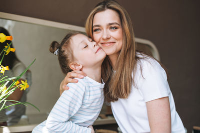 Young mother with little tween girl daughter in pajamas having fun in the morning at home