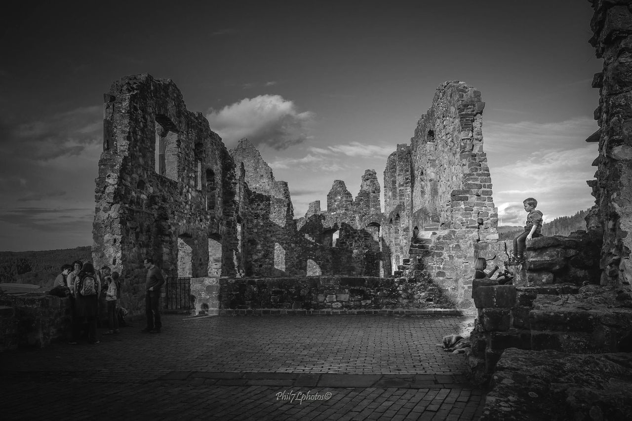 architecture, built structure, building exterior, sky, history, old, cloud - sky, building, tree, outdoors, cloud, old ruin, sunlight, day, no people, low angle view, stone wall, city, the past, ancient