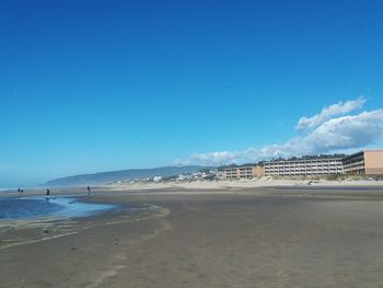 Scenic view of beach against blue sky