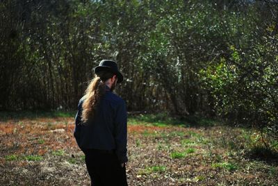 Full length of man standing on field by trees