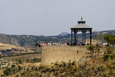 People on mountain against sky