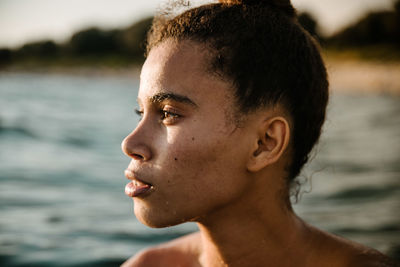 Close-up of thoughtful young woman swimming in sea