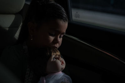 Portrait of girl playing with doll 