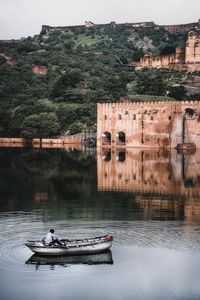 Lake in front of a historic fort in amer fort, india. surrounded by dense vegetation and a huge lake