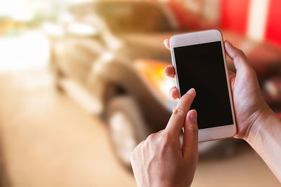 Midsection of person using mobile phone outdoors