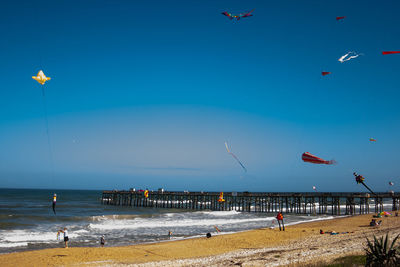 Scenic view of beach against clear blue sky