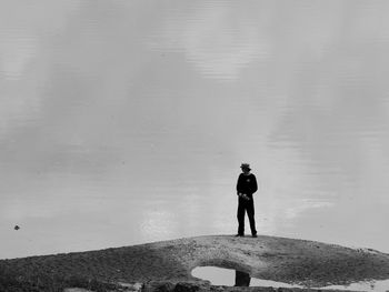 Rear view of man standing by lake