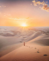 Scenic view of desert against sky during sunset