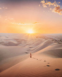 Scenic view of desert against sky during sunset