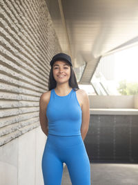 Portrait of cheerful young woman in sportswear on a sunset