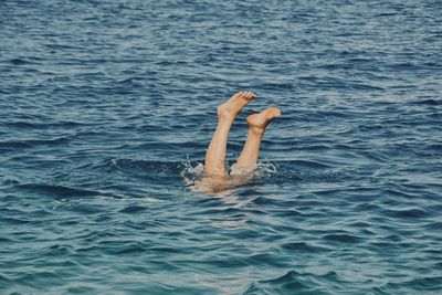 Low section of woman diving in sea